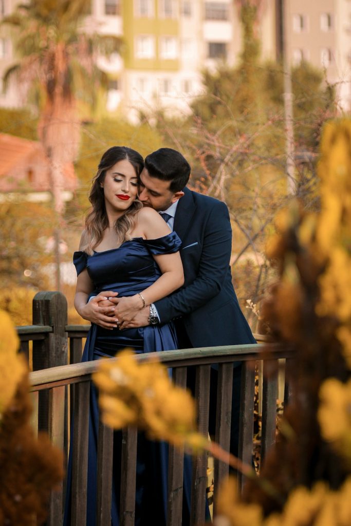 a-man-and-woman-embracing-each-other-on-a-bridge-caq-hklghmc